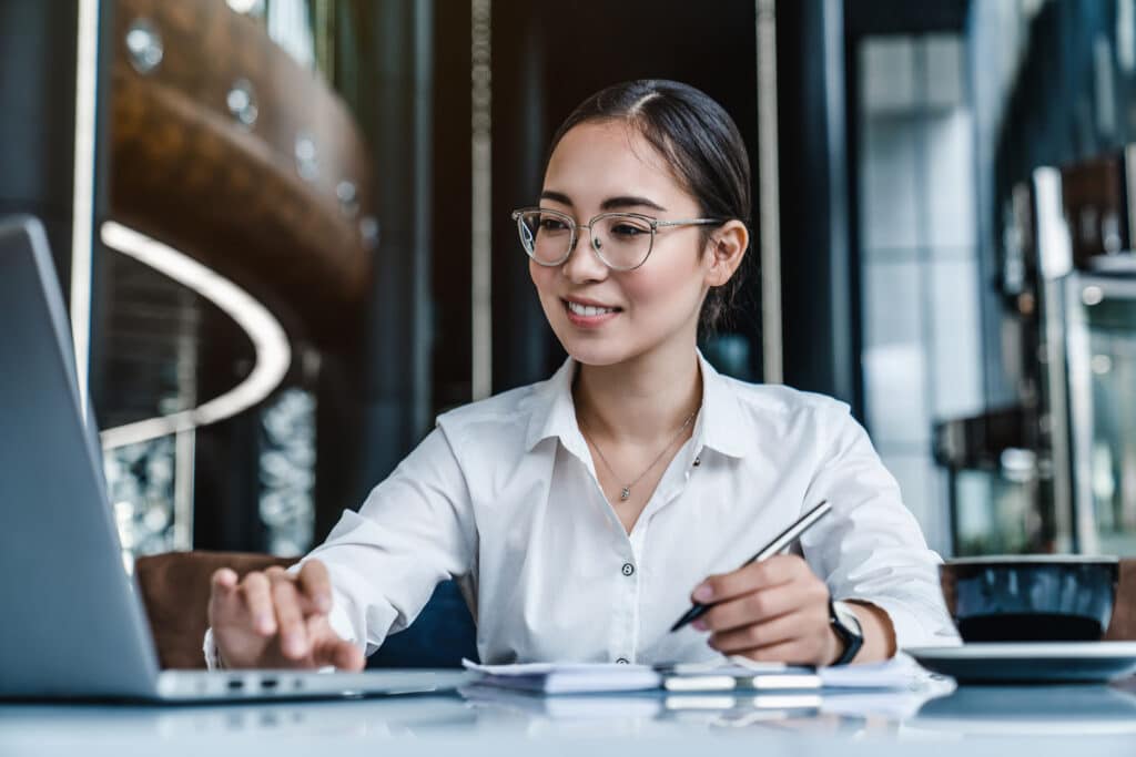 Business woman smiling at laptop on desk