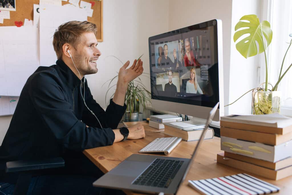 Young man having Zoom video call via a computer in home office